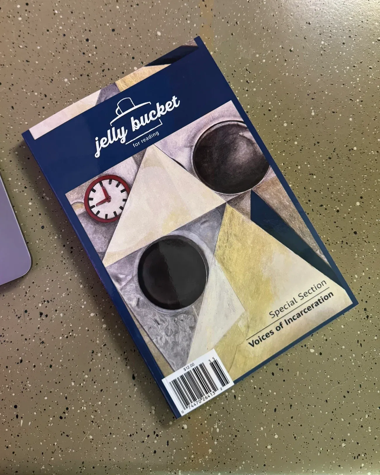A copy of Jelly Bucket with a navy cover and a special section titled Voices of Incarceration.
